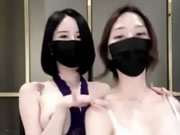 Due bellissime ragazze asiatiche con le maschere danzano